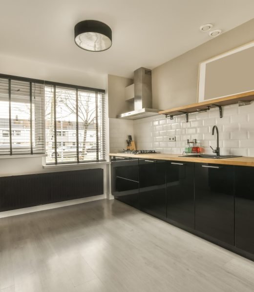 Spacious kitchen with dark furniture and wooden countertops in a modern house